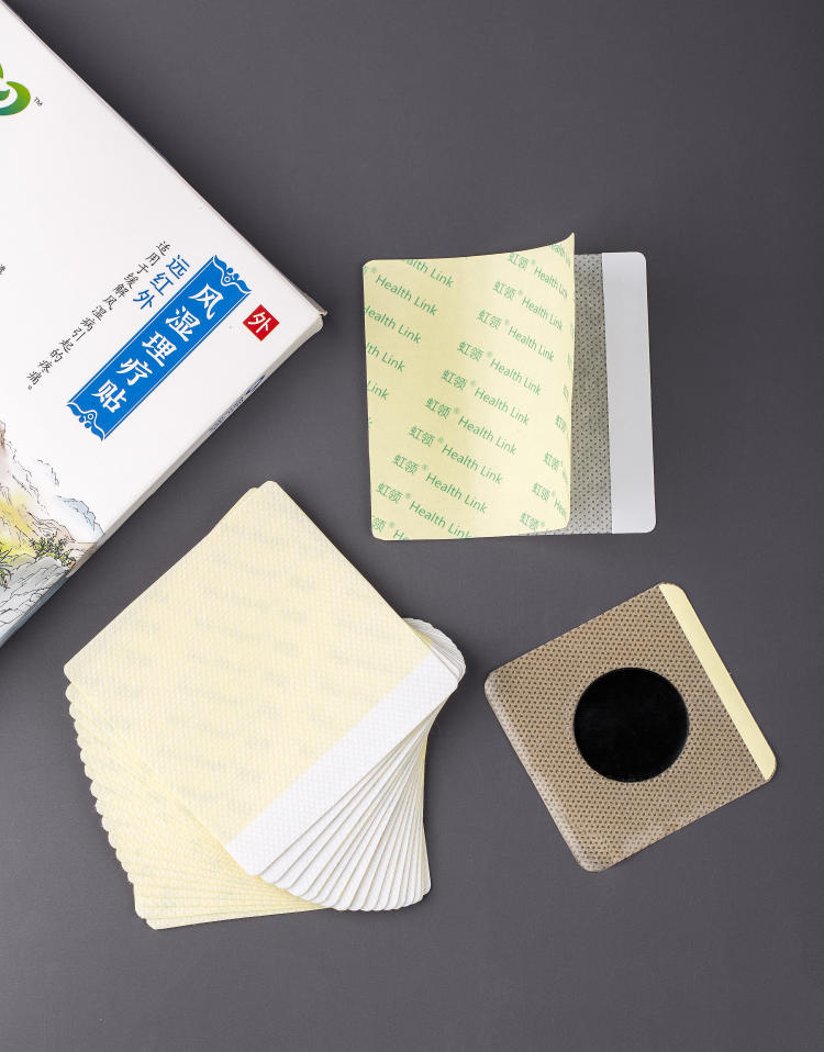 无纺布药贴平铺实物：扇形堆叠的贴片样品、圆形黑色药芯贴片，配绿白包装盒；离型纸上印有品牌标识